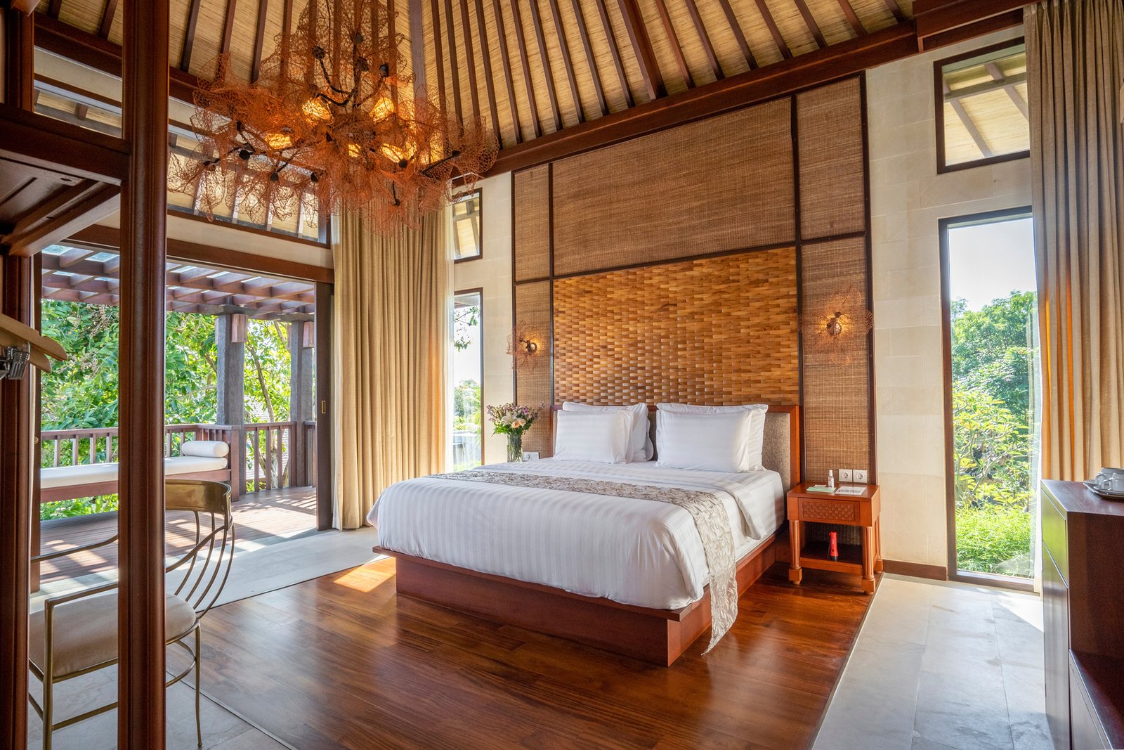 A villa bedroom open to a garden terrace